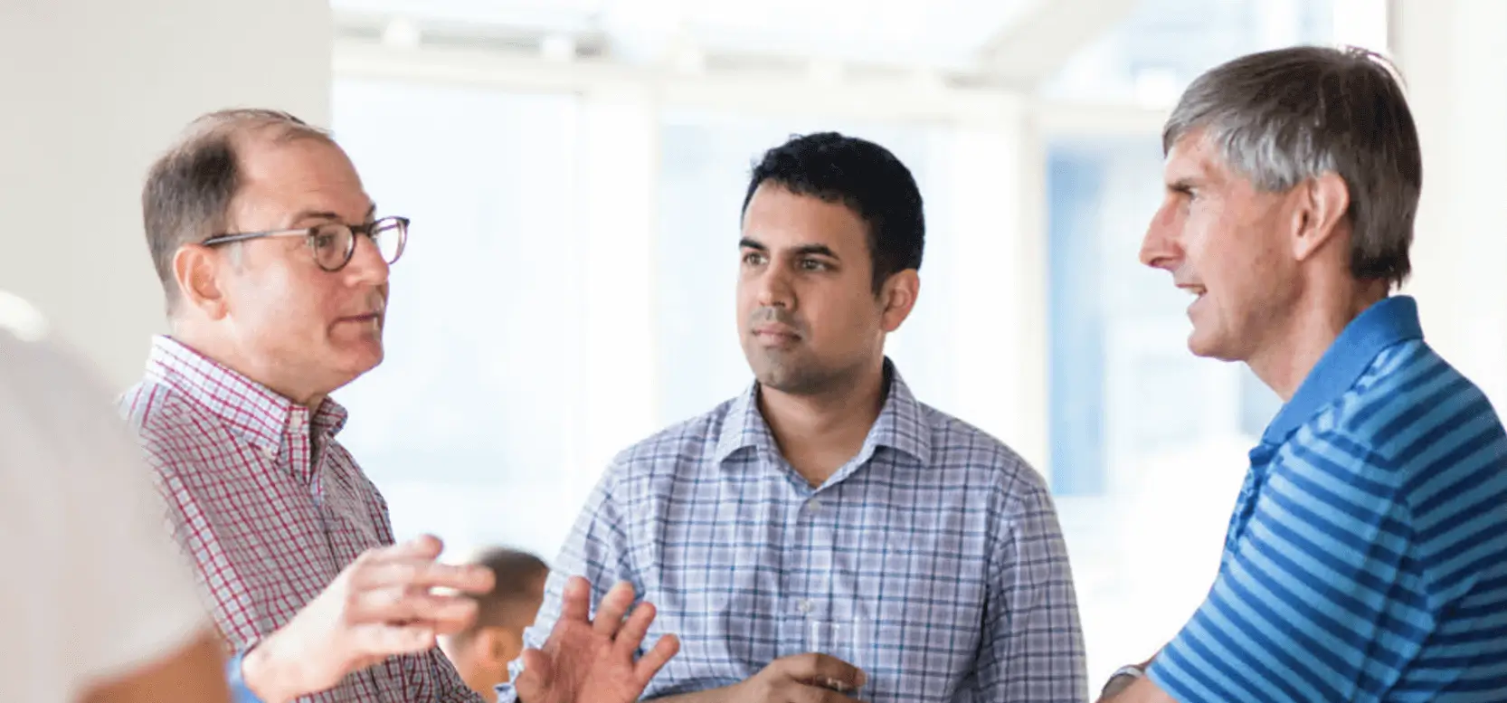 Three Viking employees in deep conversation with each other